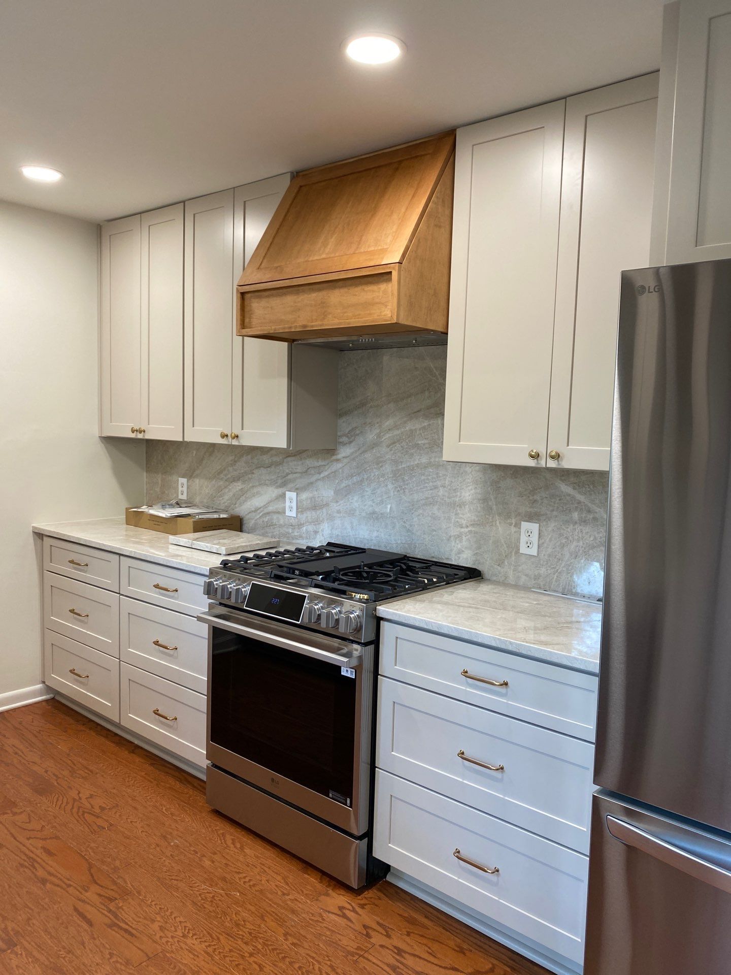 A kitchen with white cabinets , stainless steel appliances , and a large window.