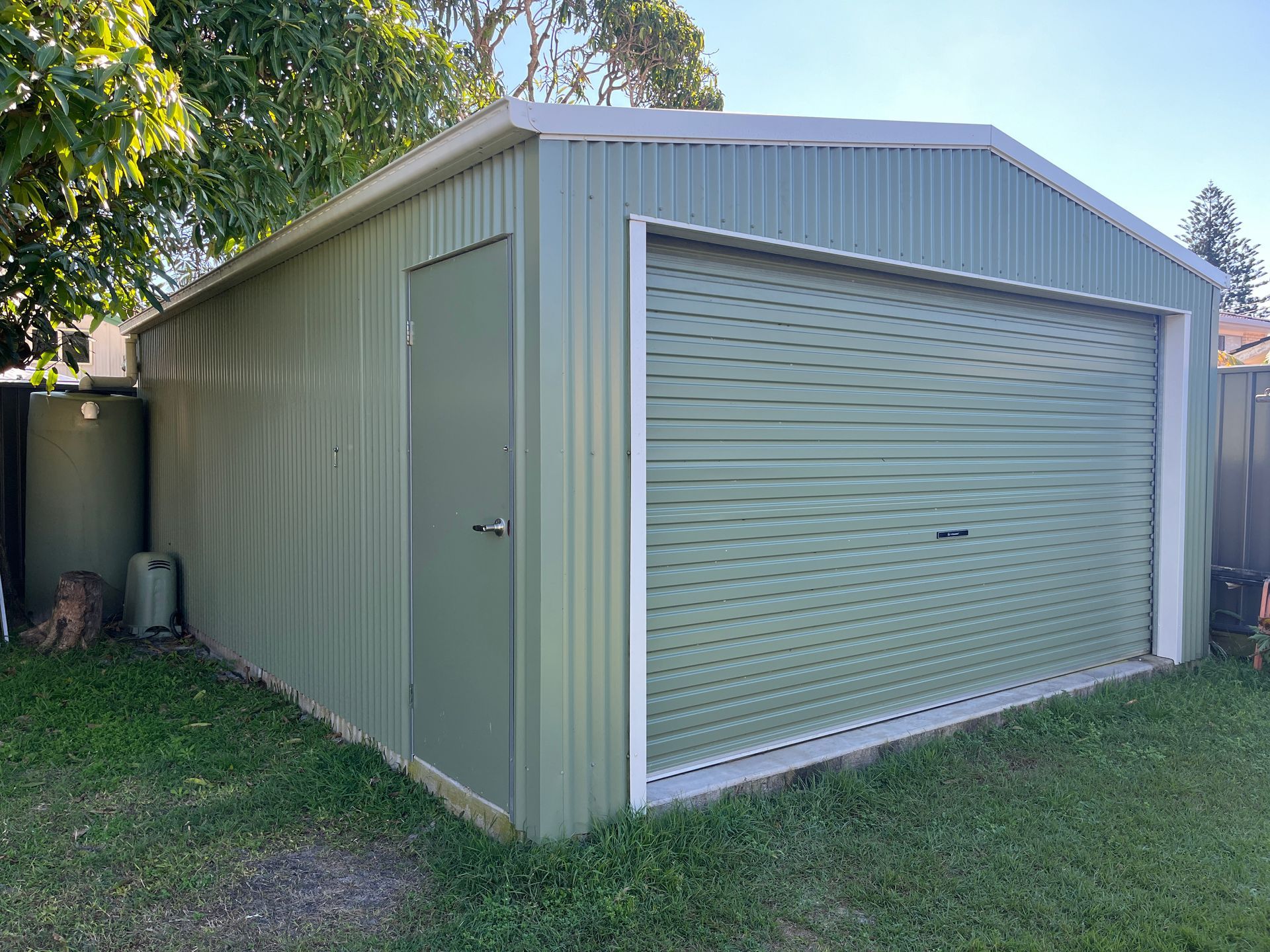 A Shed Is Sitting In The Middle Of A Lush Green Field — Urbon Sheds in Mullumbimby, NSW