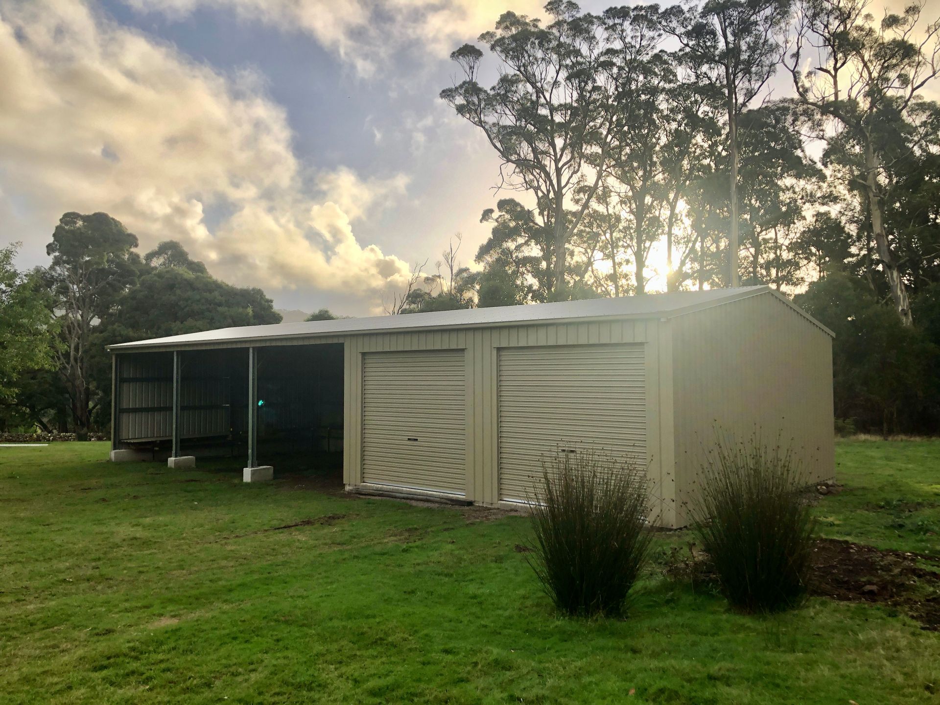A Shed Is Sitting In The Middle Of A Lush Green Field — Urbon Sheds in Mullumbimby, NSW