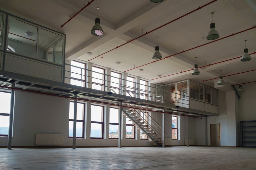 A Large Empty Room With Stairs Leading Up to the Second Floor — Urbon Sheds in Uki, NSW