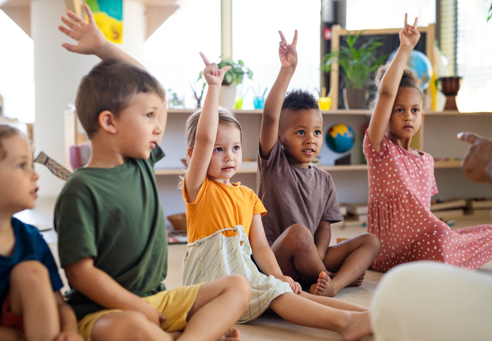A group of kids is raising their hands.