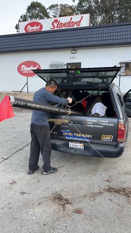 A man is loading something into the back of a truck.