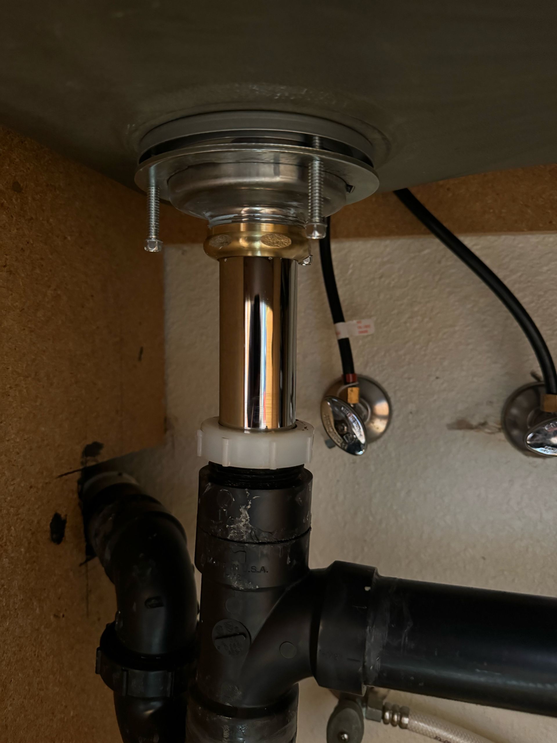 A close up of a sink with pipes underneath it