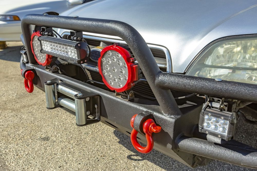Front view of a silver truck with a black off-road bumper, red tow hooks, and mounted lights — Stay on Track 4X4 Accessories in Gladstone Central, QLD