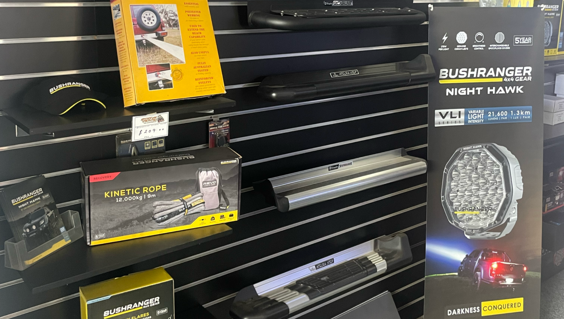 Store display of Blackhawk tactical accessories on black shelves, with packaged gear and a watch-like item — Stay on Track 4X4 Accessories in Gladstone Central, QLD