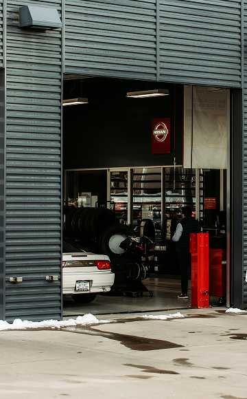 Car in Auto Repair Shop, Tires Stacked, Red Canister — Stay on Track 4X4 Accessories in Gladstone Central, QLD