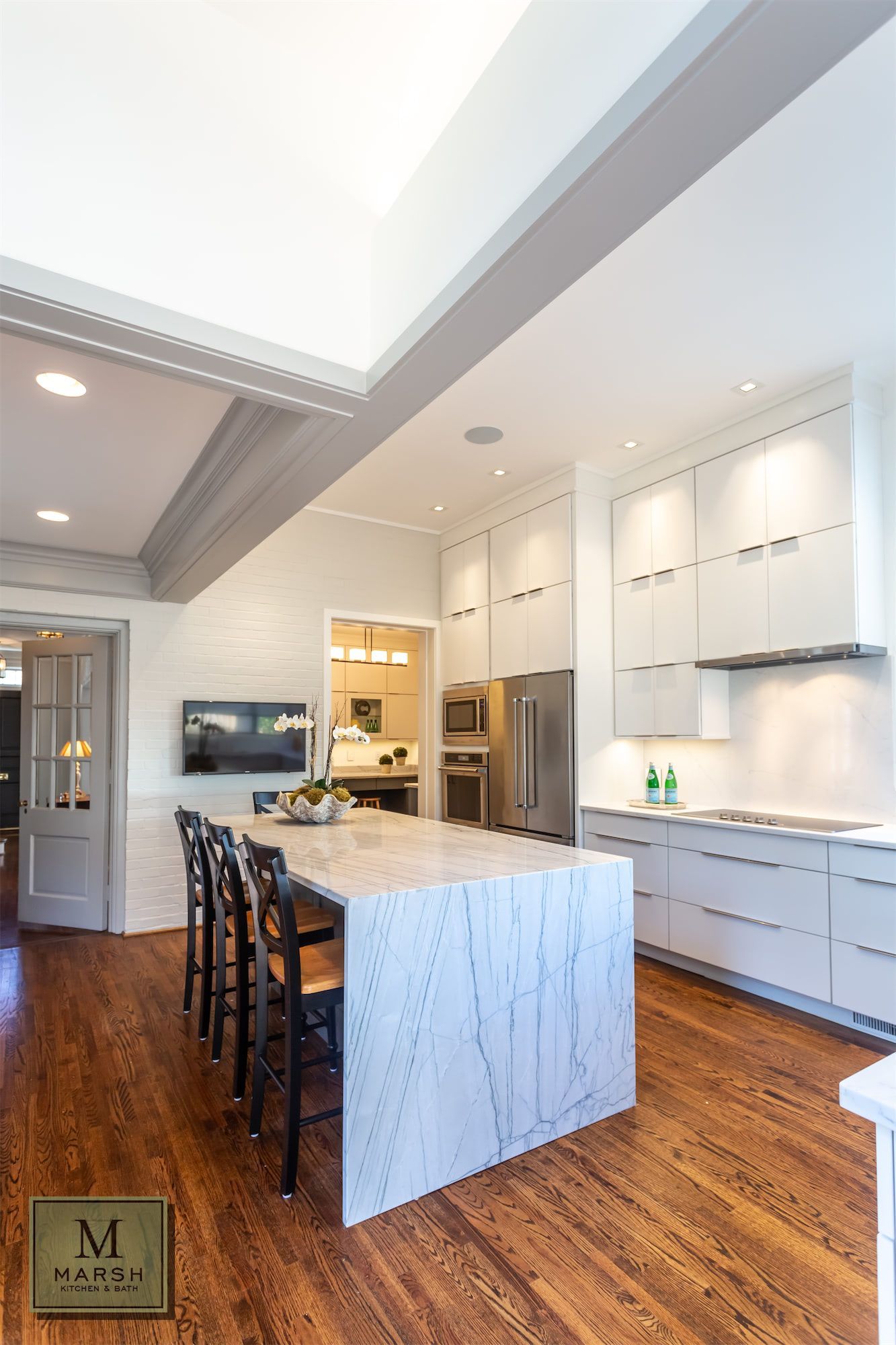A kitchen with white cabinets and a large island in the middle