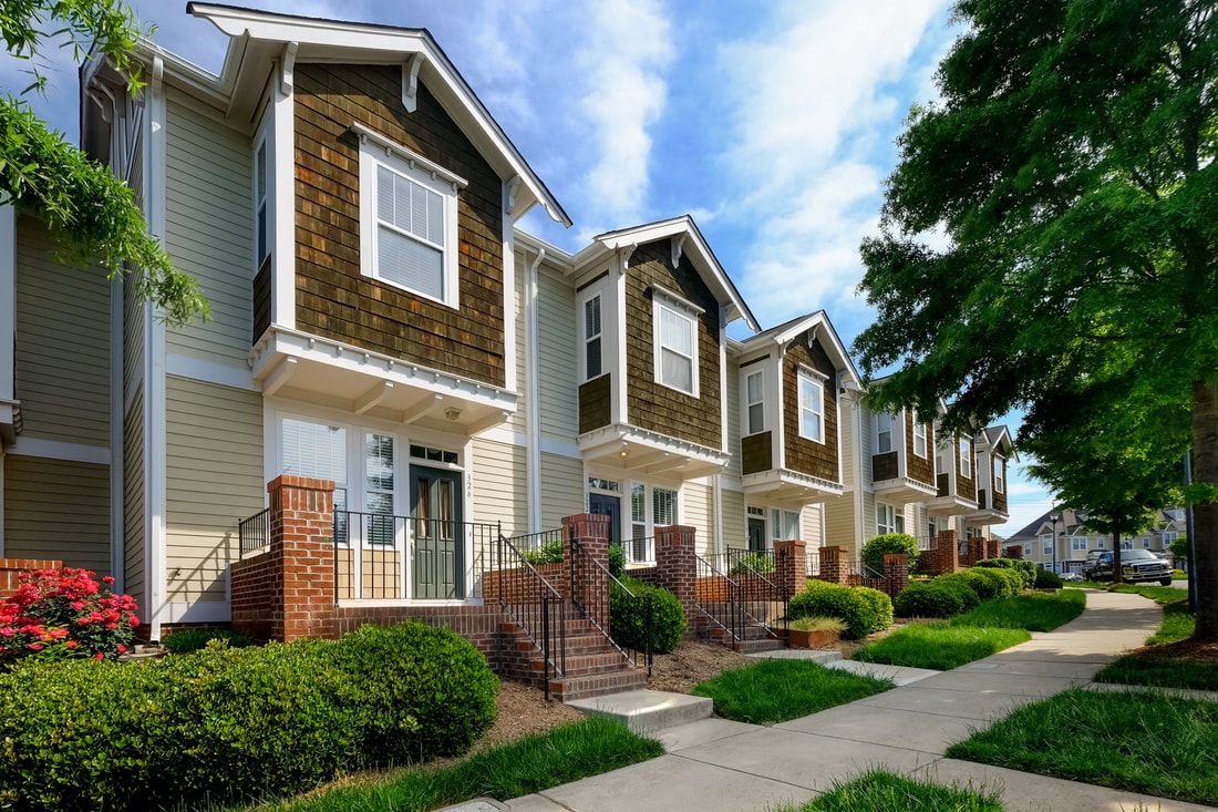A row of houses are lined up next to each other on a sunny day.