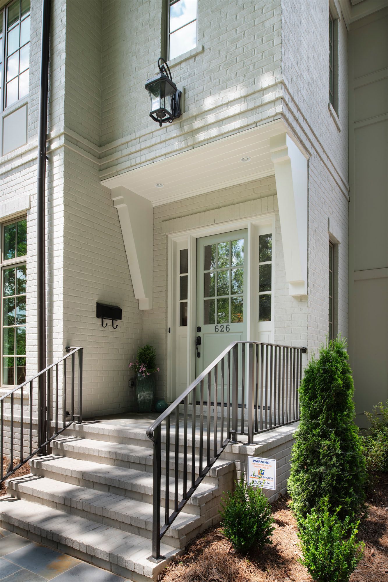 A white brick house with a white door and stairs