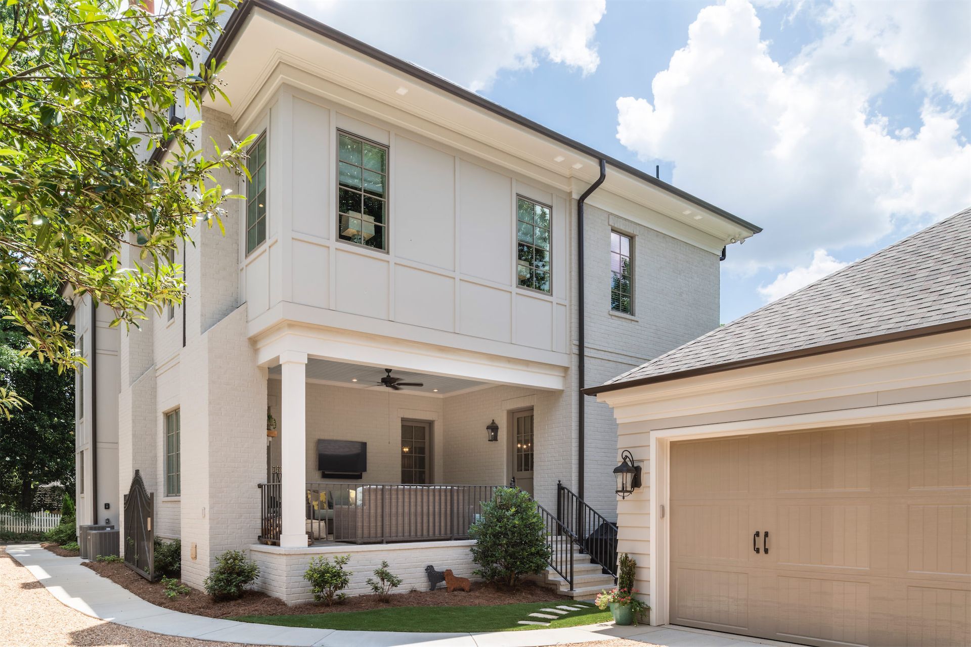 A large white house with a garage and a porch.