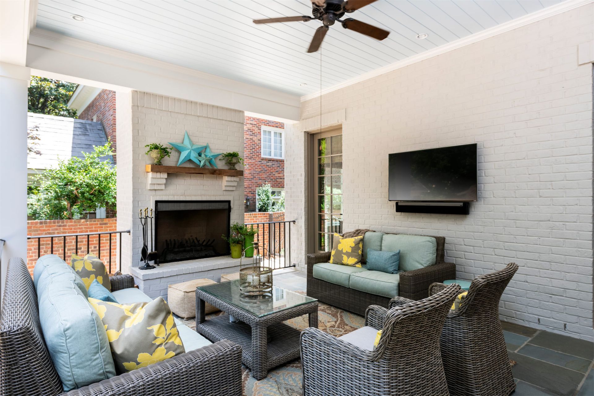A living room with a couch , chairs , a fireplace and a flat screen tv.