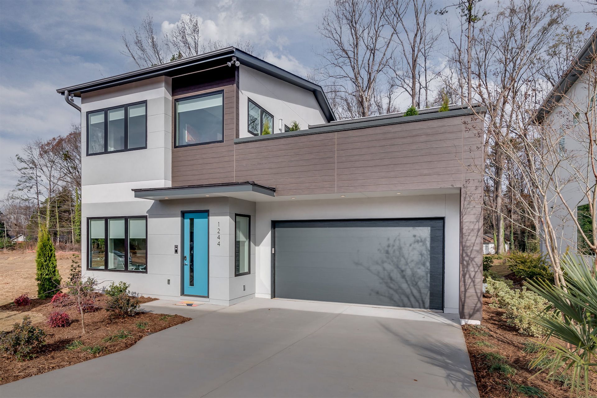 A modern house with a large garage and a blue door.