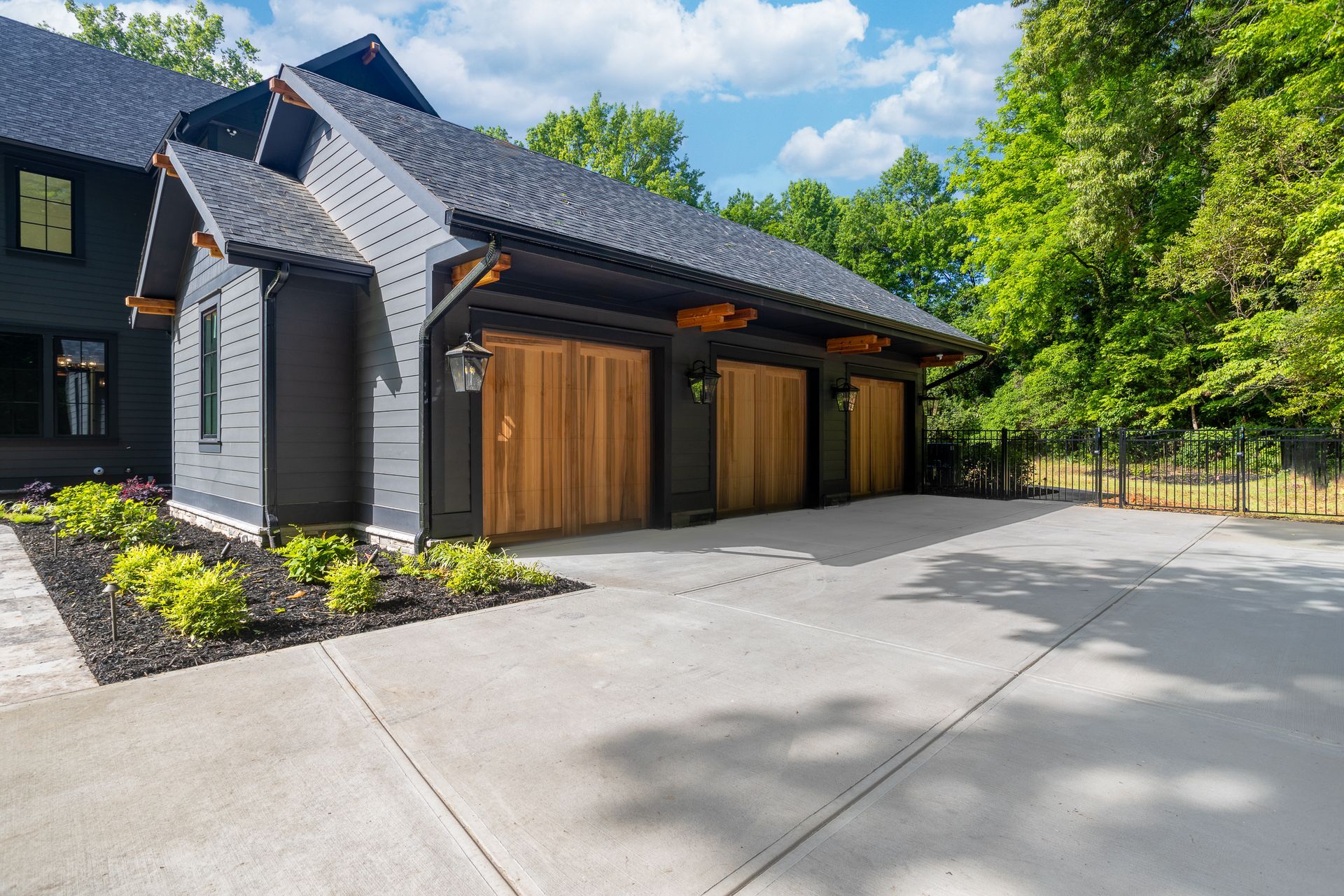 A large house with three garage doors and a driveway.
