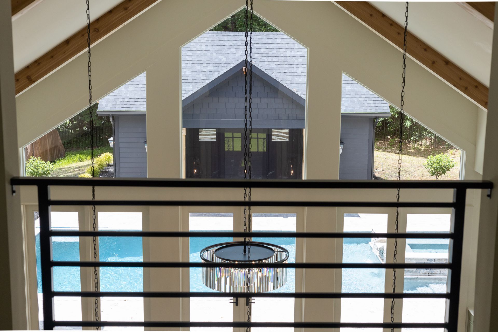 A view of a swimming pool from the balcony of a house