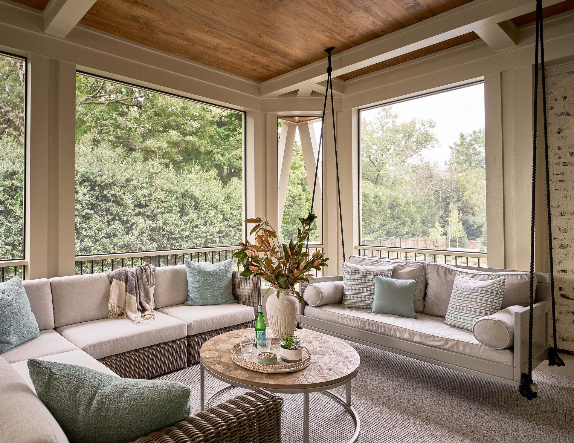 A living room with a couch , table , and swing.