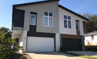 a modern house with a white garage door and a lot of windows .