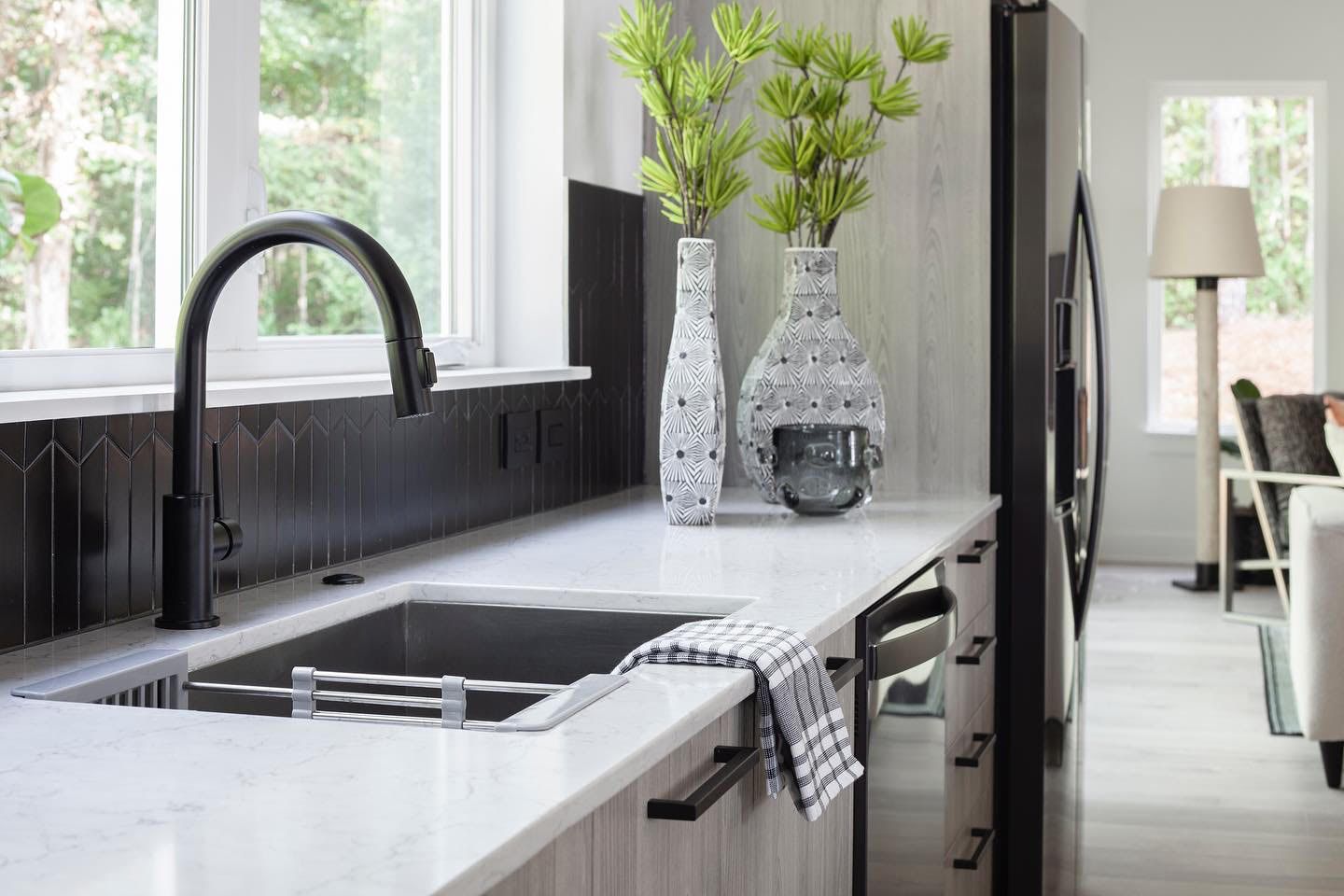a kitchen with a sink , refrigerator , dishwasher , and window .