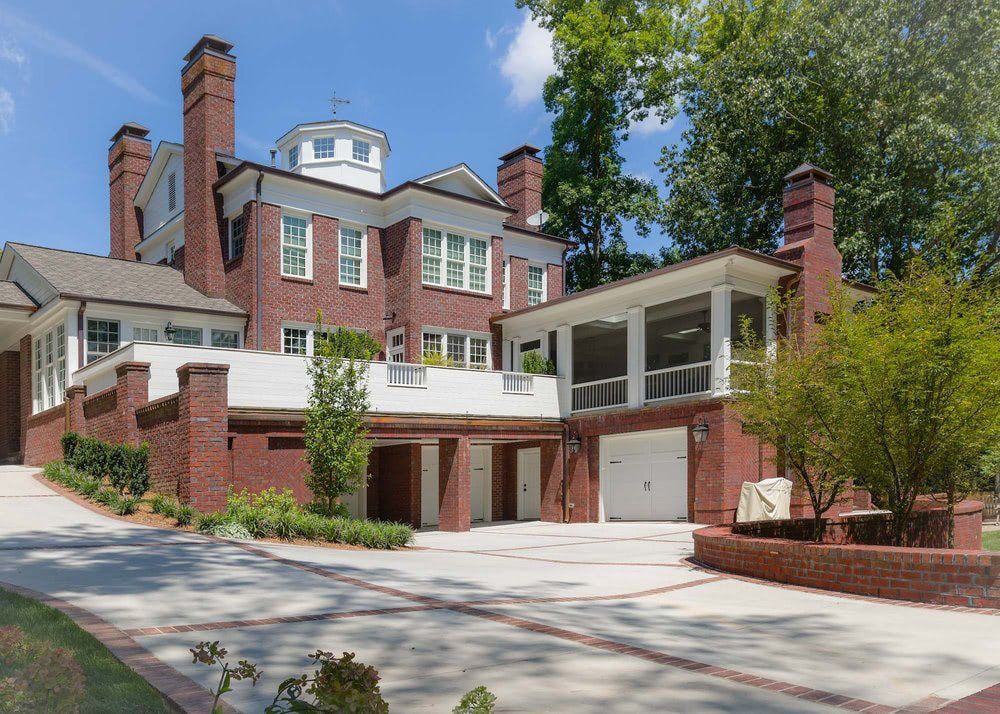 A large brick house with two garages and a large driveway.