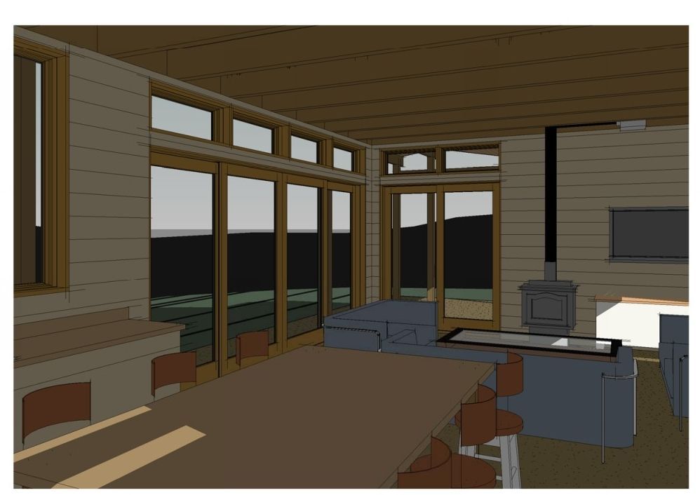 Wooden cabin living room with large windows overlooking mountains at sunset