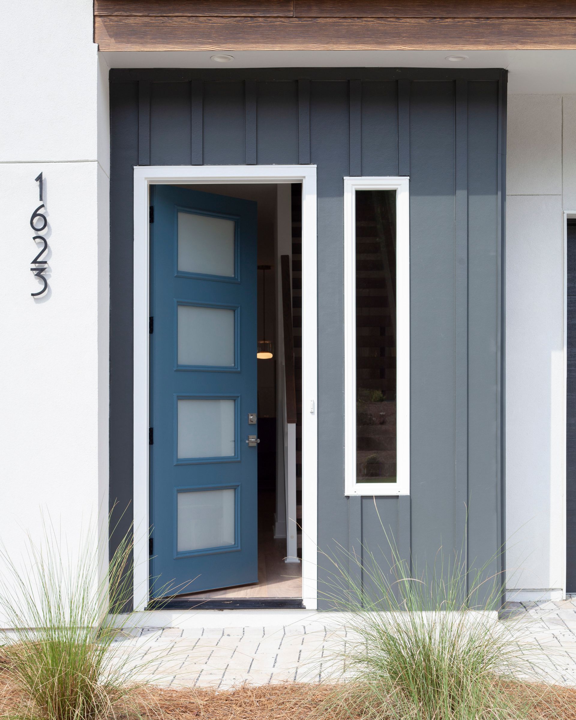 The front door of a house with a blue door and a window