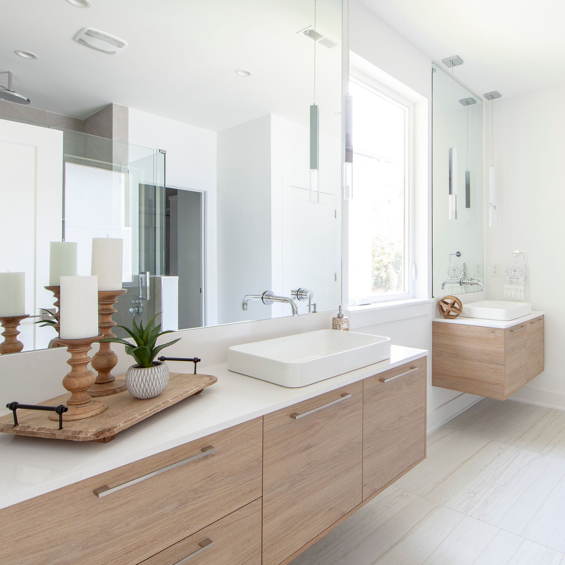 A bathroom with two sinks and a large mirror