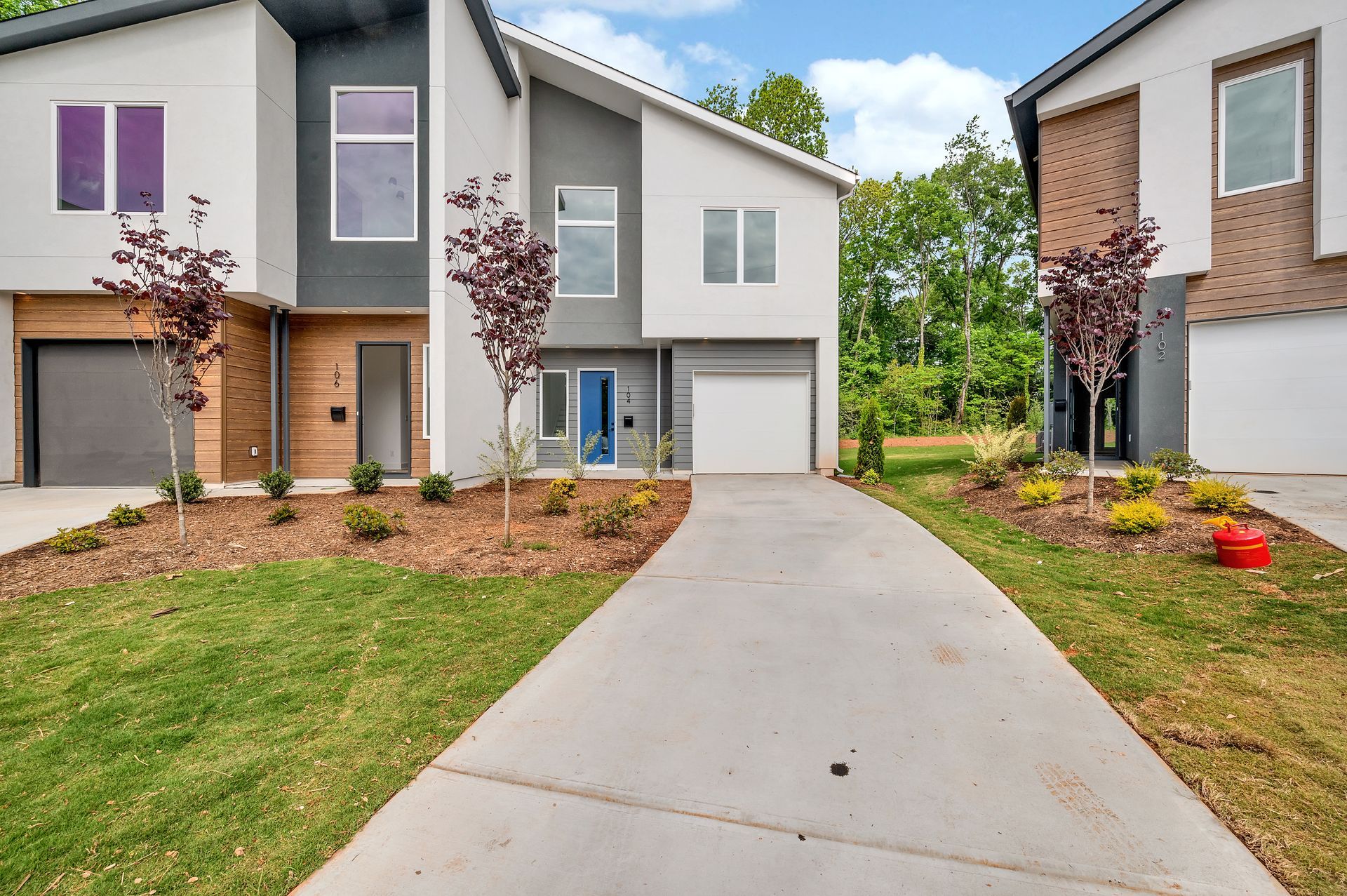A modern house with a concrete driveway leading to it