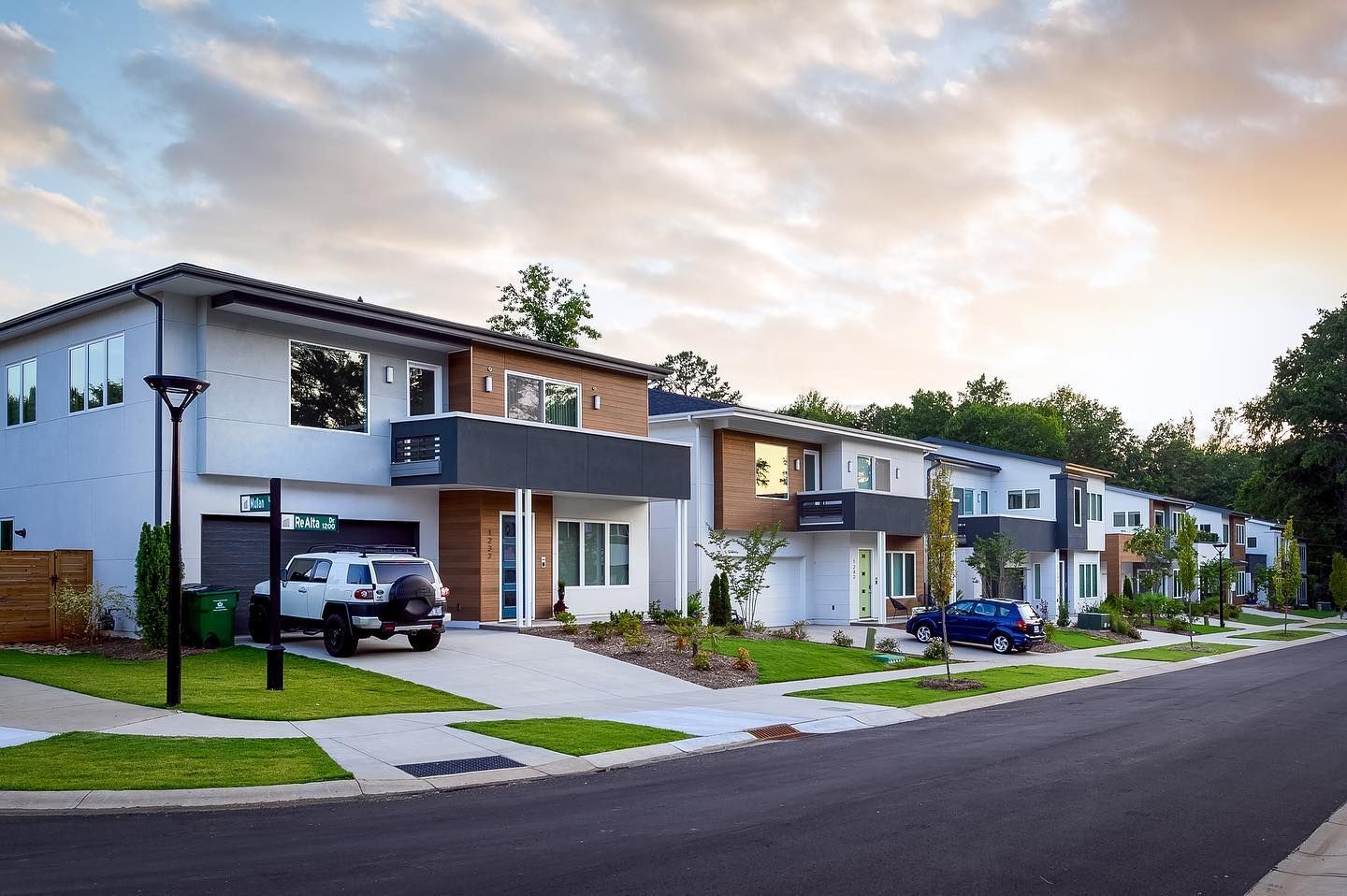 A row of houses with cars parked in front of them