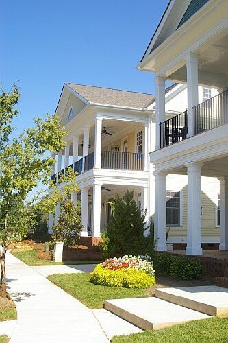 A row of white houses with porches on a sunny day