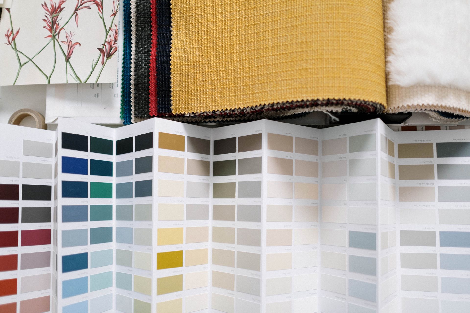 Color swatch display with rows of paint samples and folded fabric swatches above