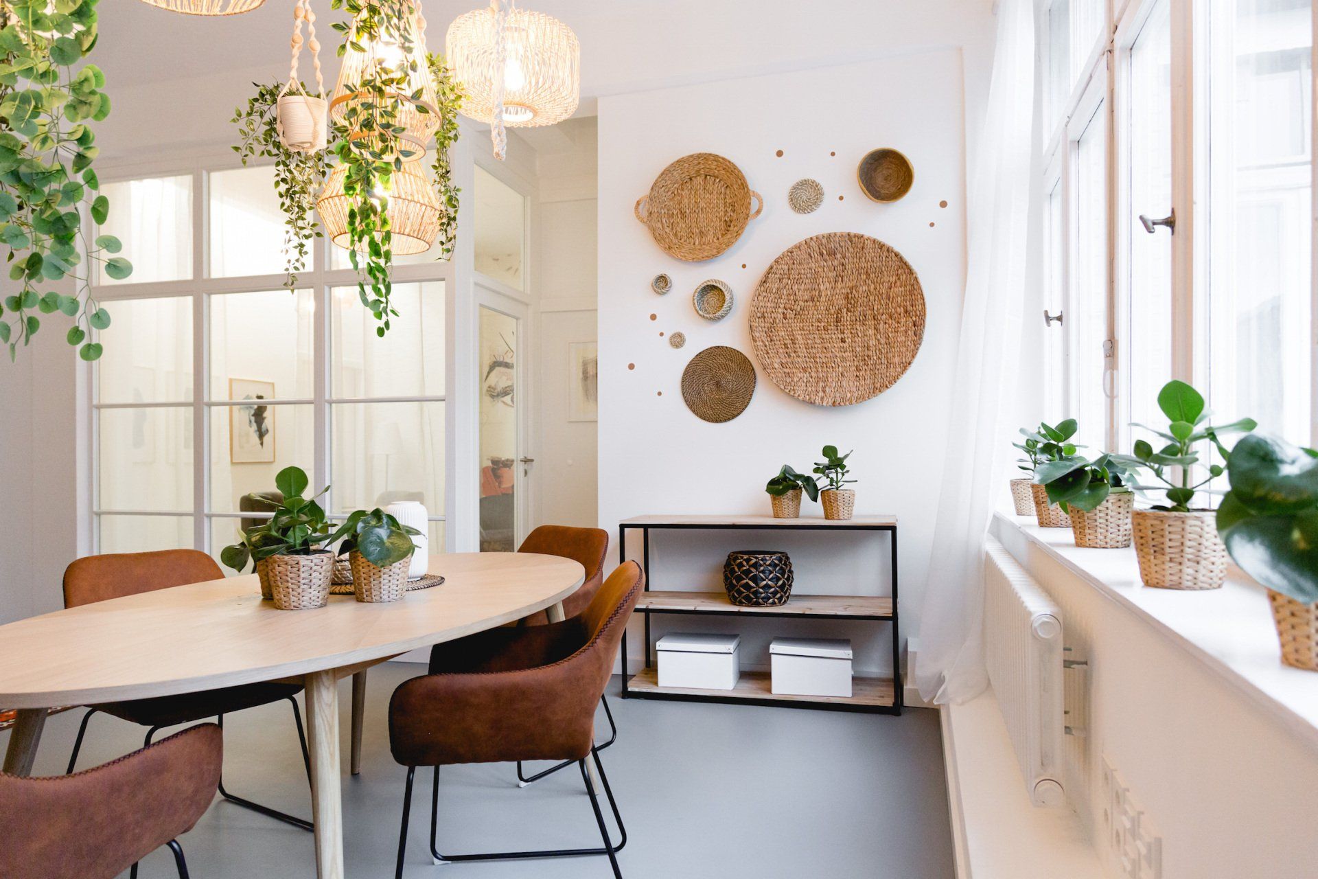 Ein Esszimmer mit Tisch und Stühlen und Pflanzen an der Wand.
