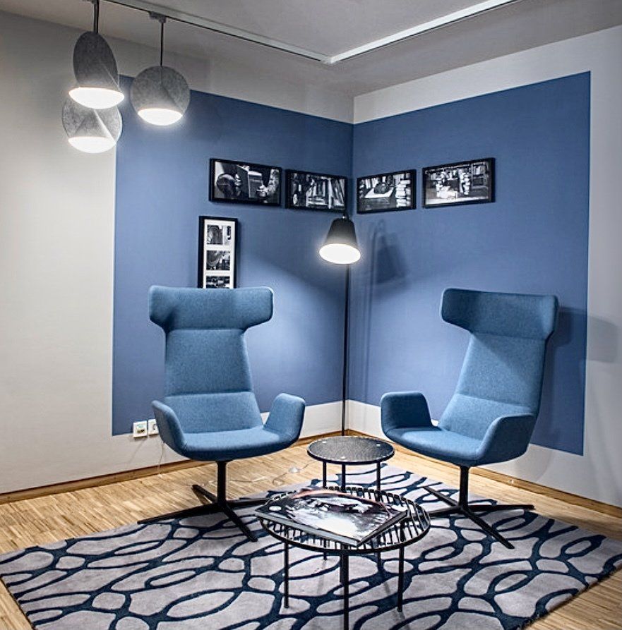 Ein Wohnzimmer mit blauen Stühlen und einem Teppich