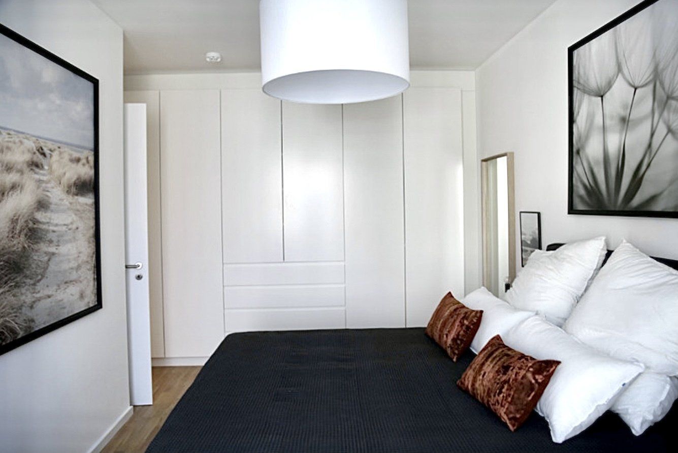 Ein Schlafzimmer mit einem Bett und zwei Bildern an der Wand