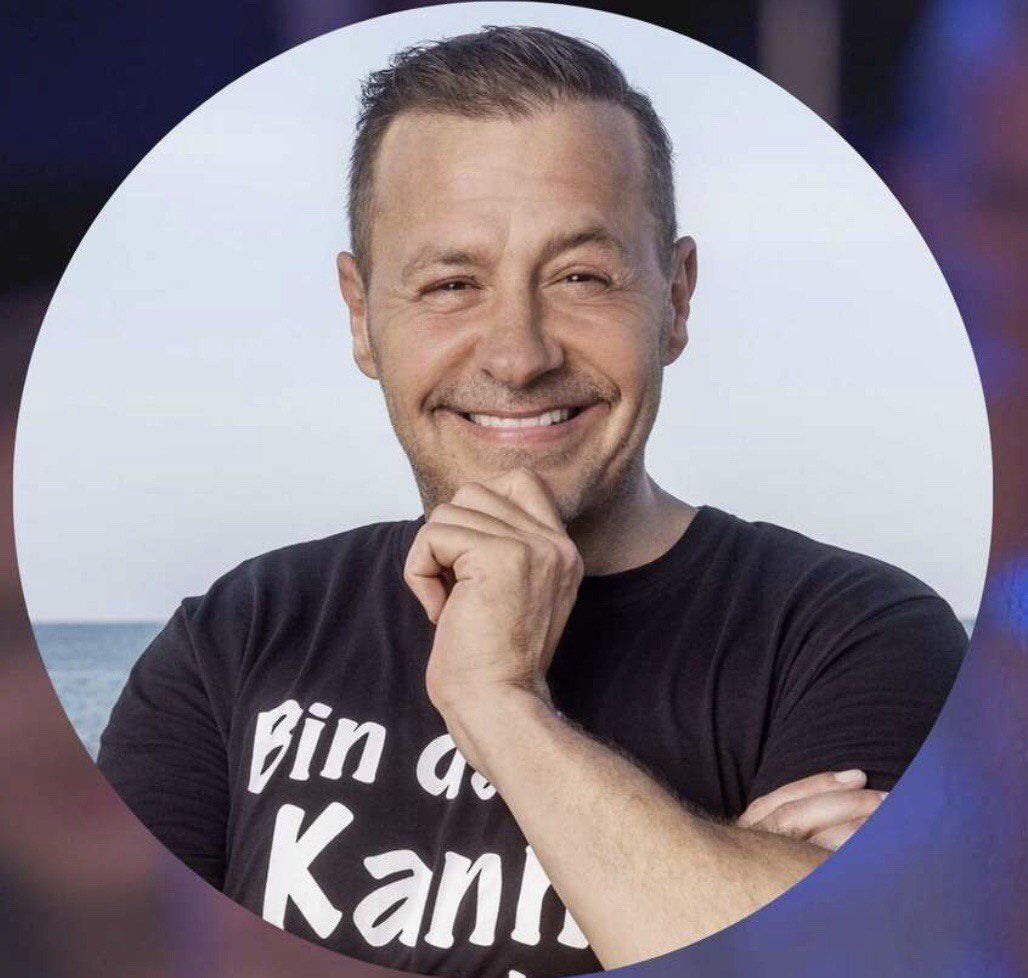 Ein Mann trägt ein schwarzes Hemd mit der Aufschrift „bin a kan“