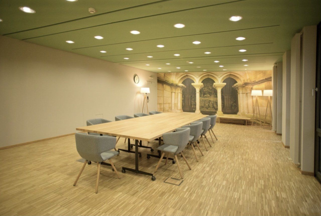 Ein Konferenzraum mit einem langen Tisch und Stühlen.