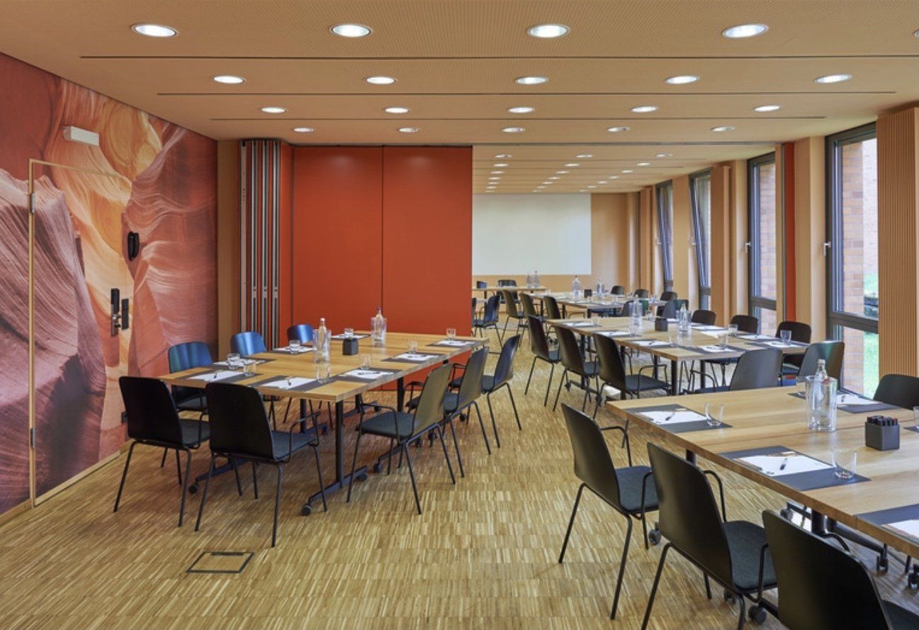 Ein großer Konferenzraum mit Tischen und Stühlen für eine Besprechung.