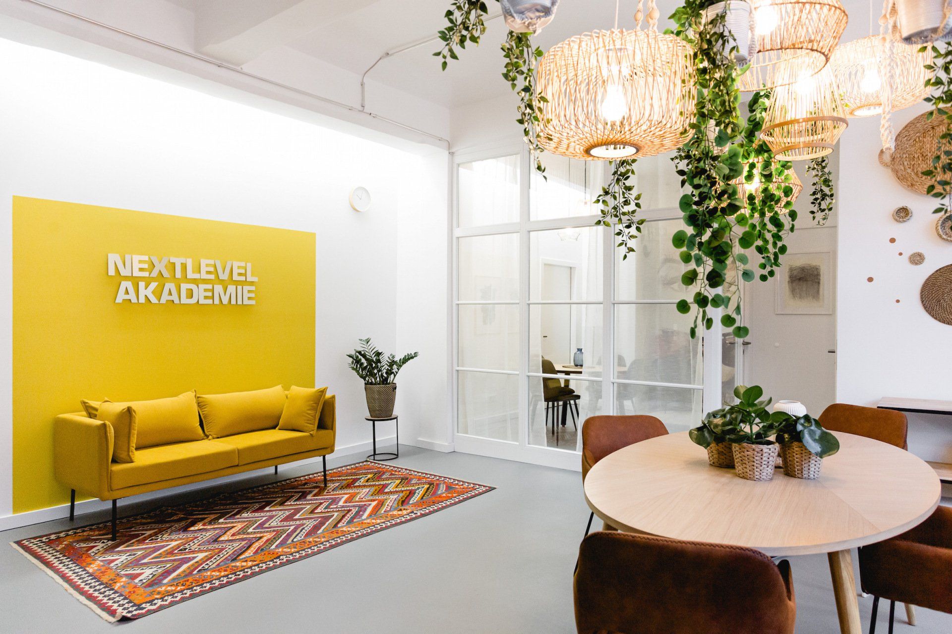 Ein Wohnzimmer mit einer gelben Couch, einem Tisch und Stühlen.