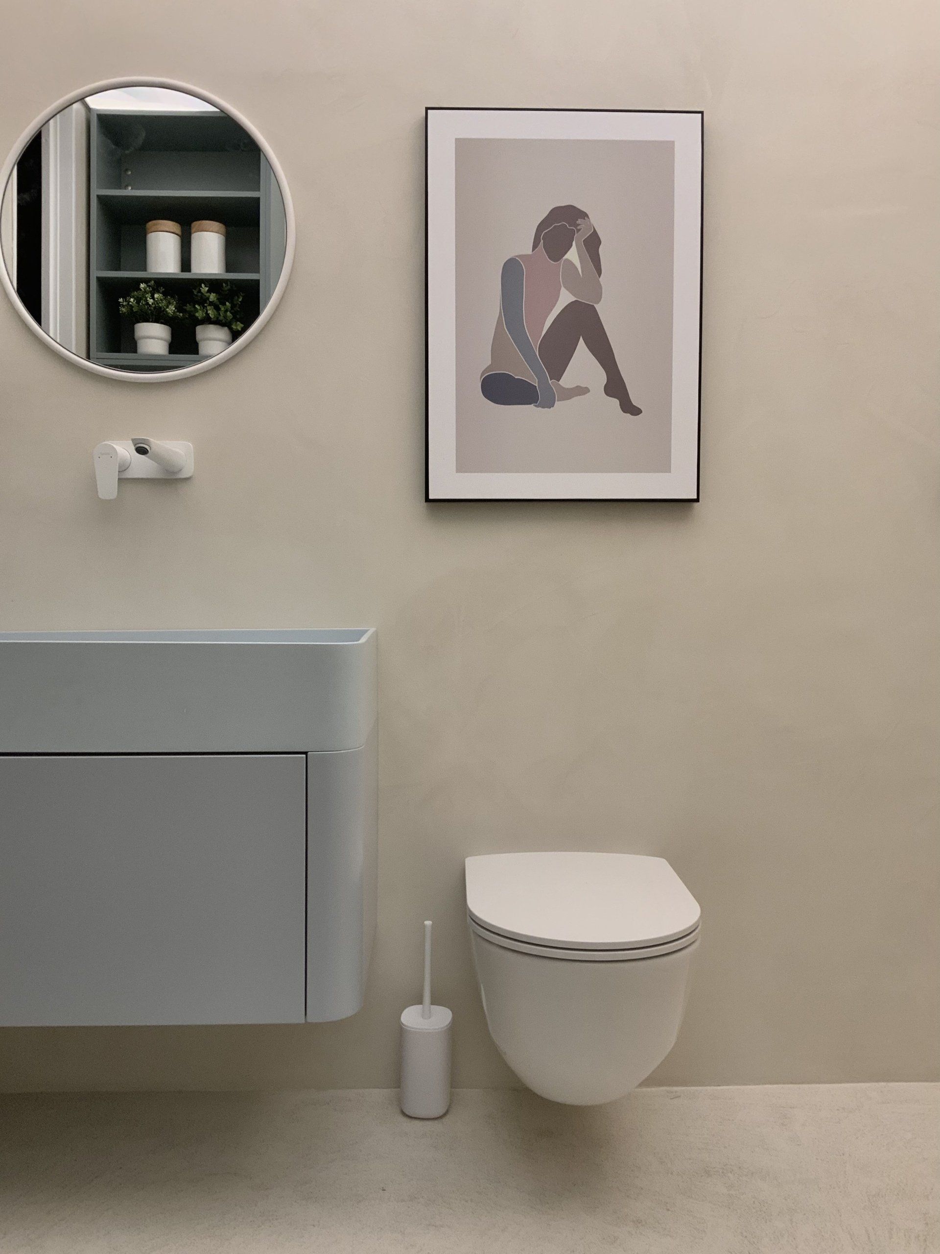Ein Badezimmer mit Toilette, Waschbecken und Spiegel