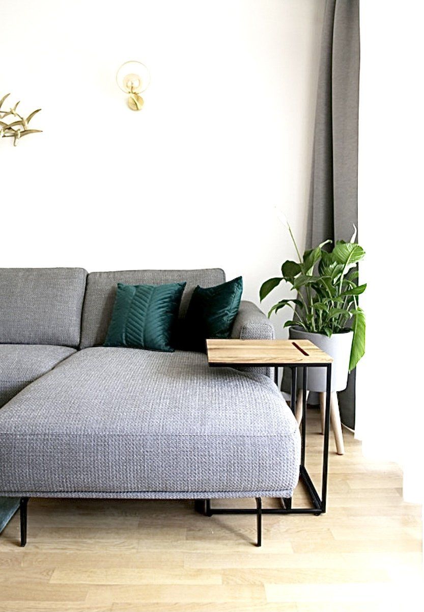 Ein Wohnzimmer mit einer grauen Sofagarnitur und einem Holztisch.