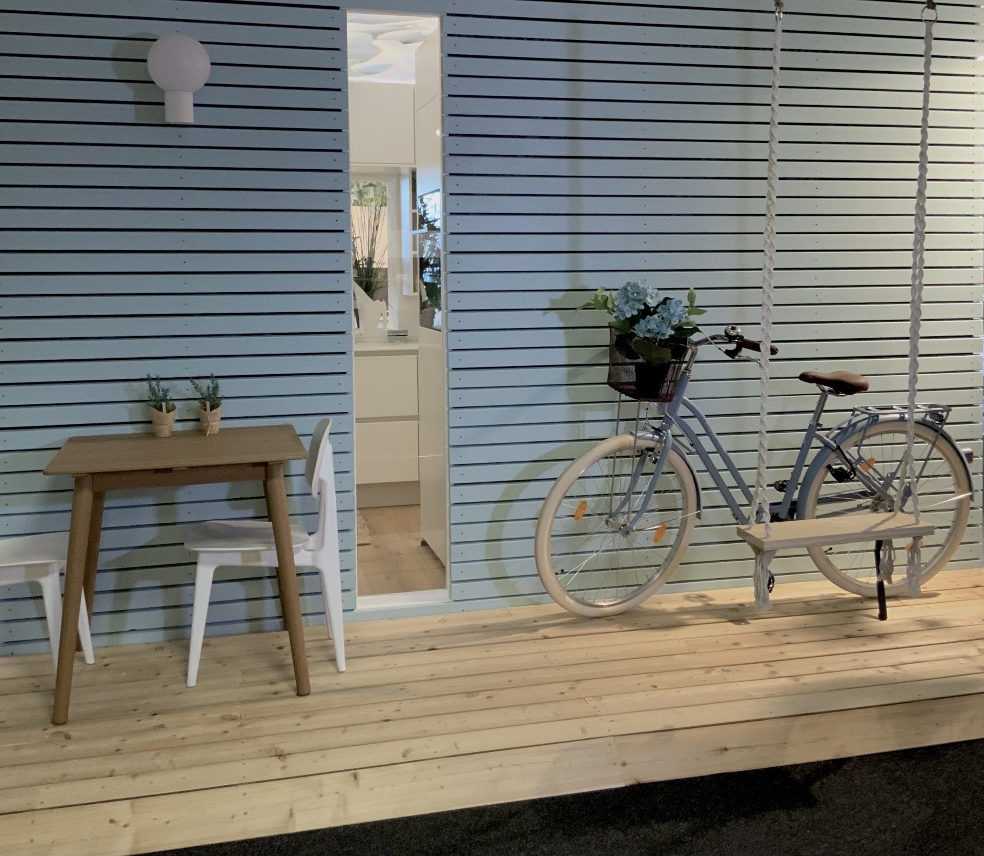 Ein Fahrrad steht auf einem Holzdeck neben einem Tisch und Stühlen
