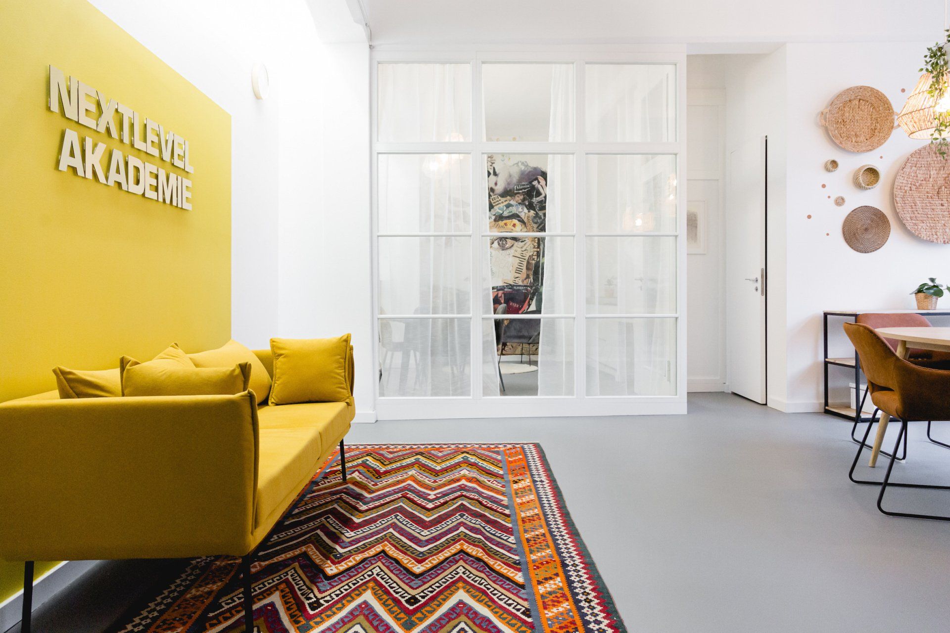 Ein Wohnzimmer mit einem gelben Sofa und einem Teppich.