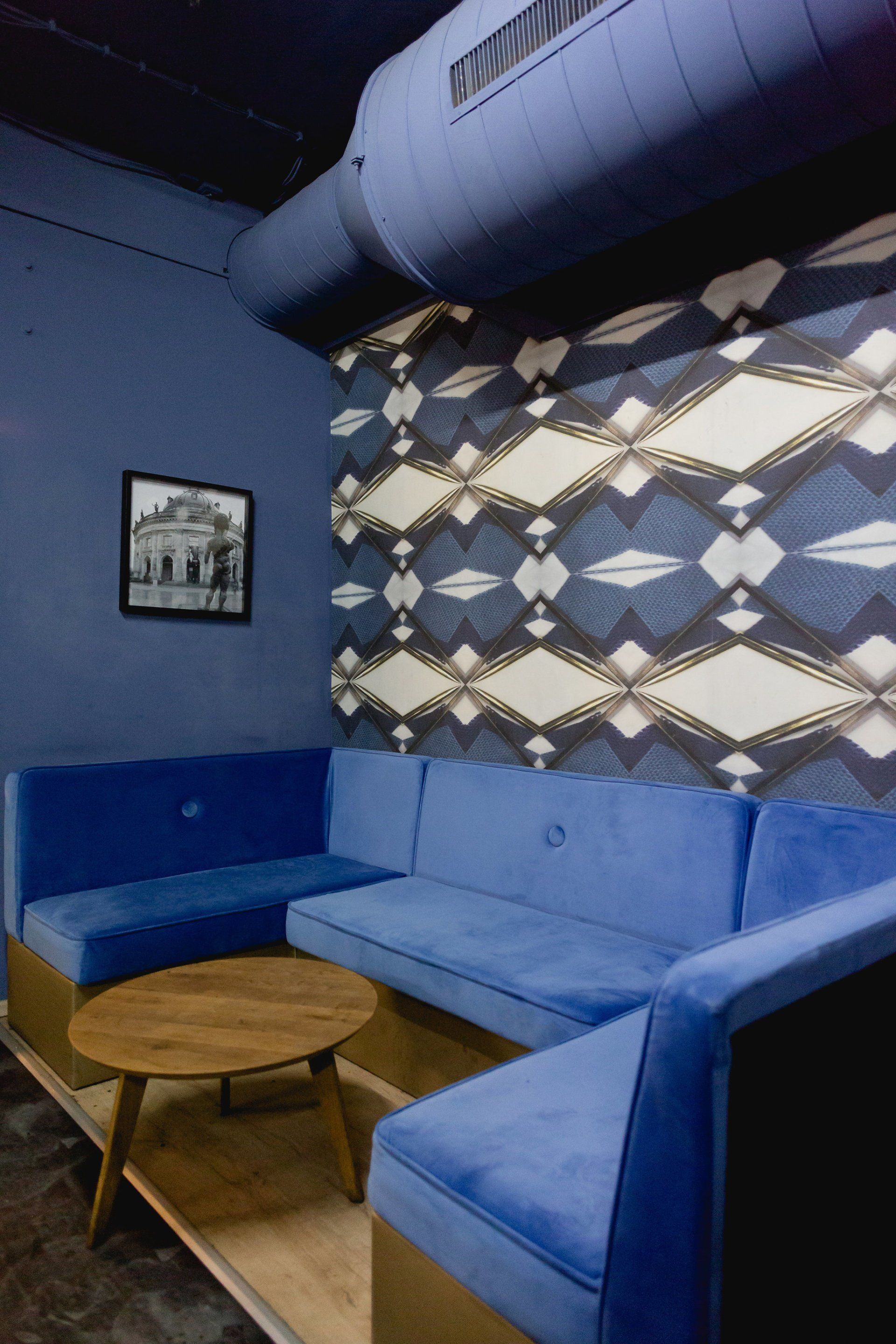 Ein Zimmer mit blauen Möbeln und einem Bild an der Wand