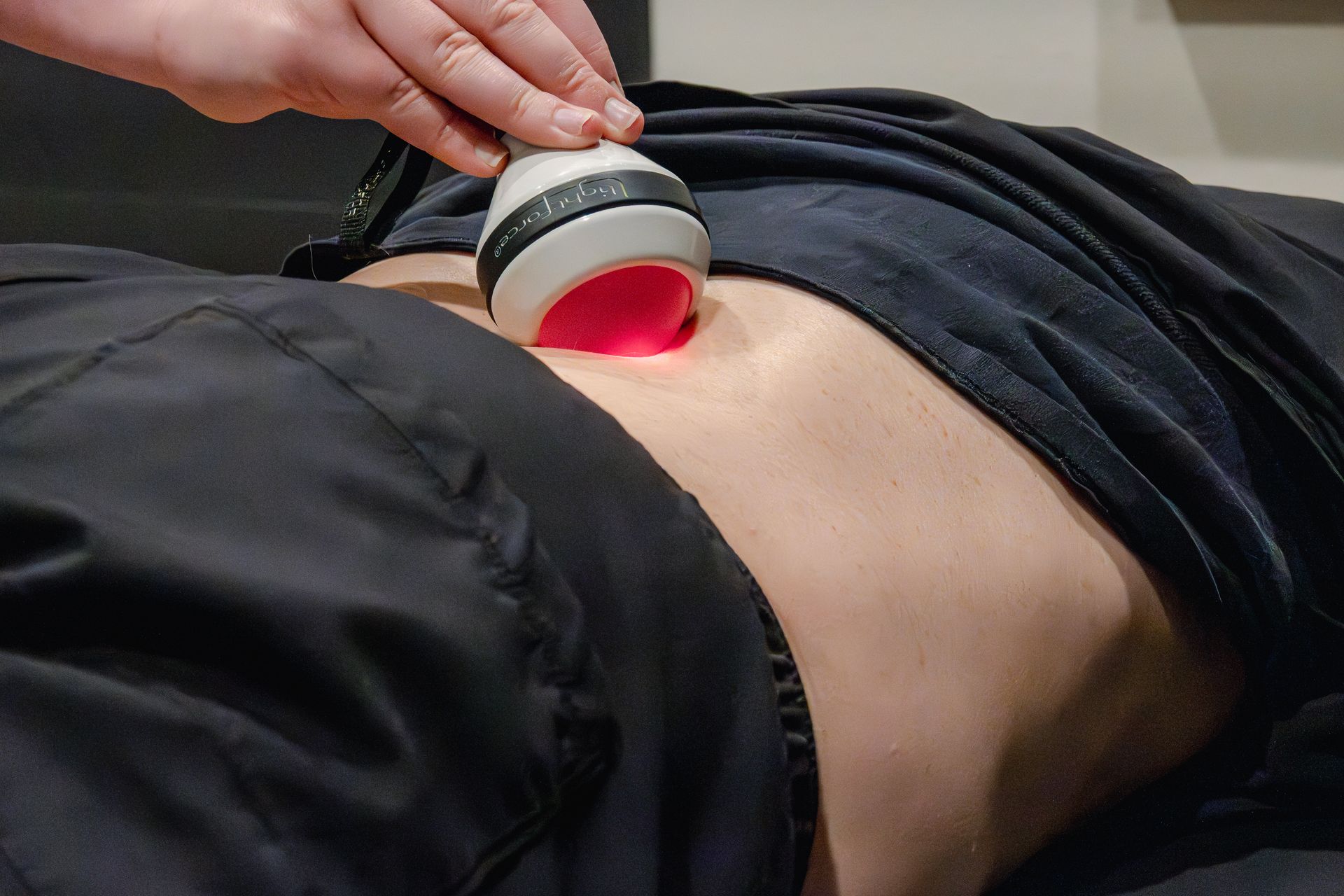 Physical therapist performing deep tissue laser therapy on patient for low back pain at MOSS Rehabilitation Center in Springtown Texas