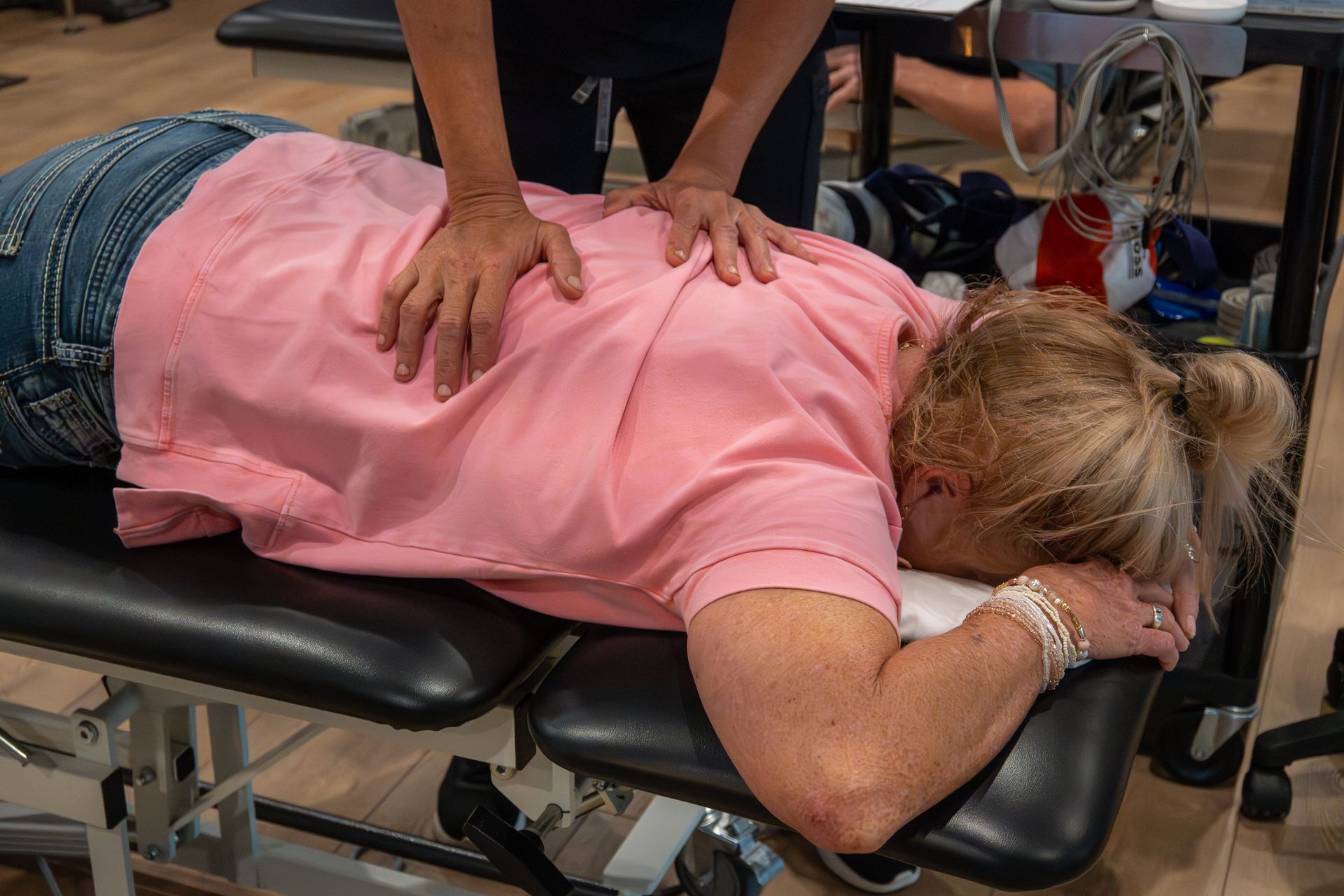 Physical therapist performing hands on therapy on patient for back pain at MOSS Rehabilitation Center in Springtown Texas