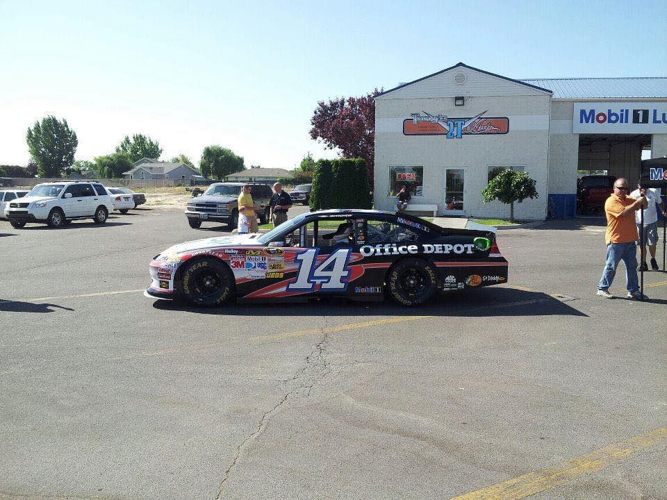 Race car, number 14, Office Depot sponsored, parked in front of a Mobil gas station.