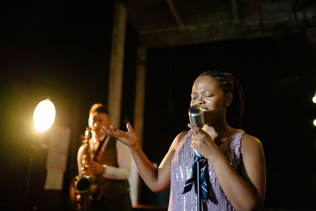 Vocalist and saxophonist performing together in a warmly lit venue, licensed stock example.