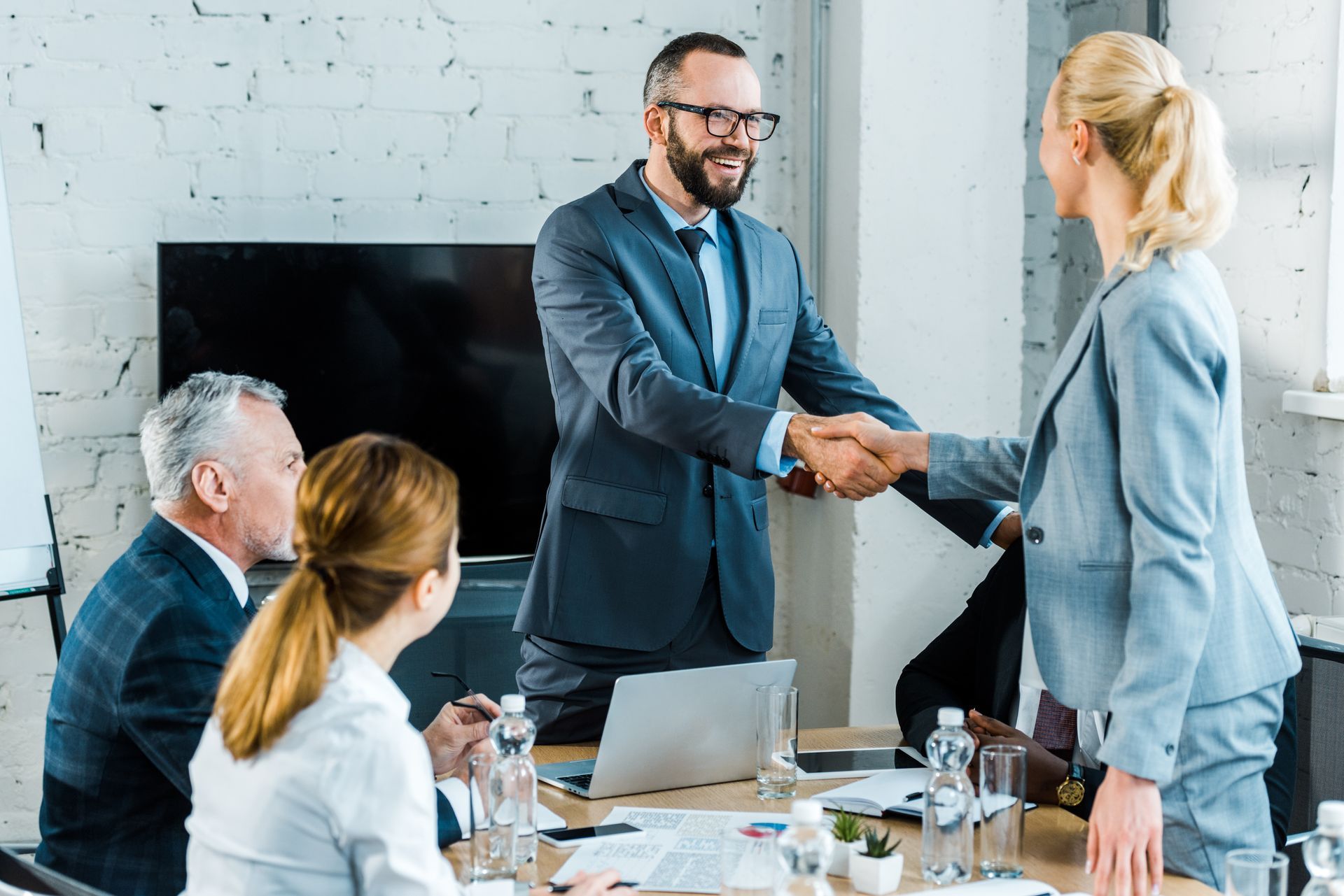 a group of business people are shaking hands in a conference room .