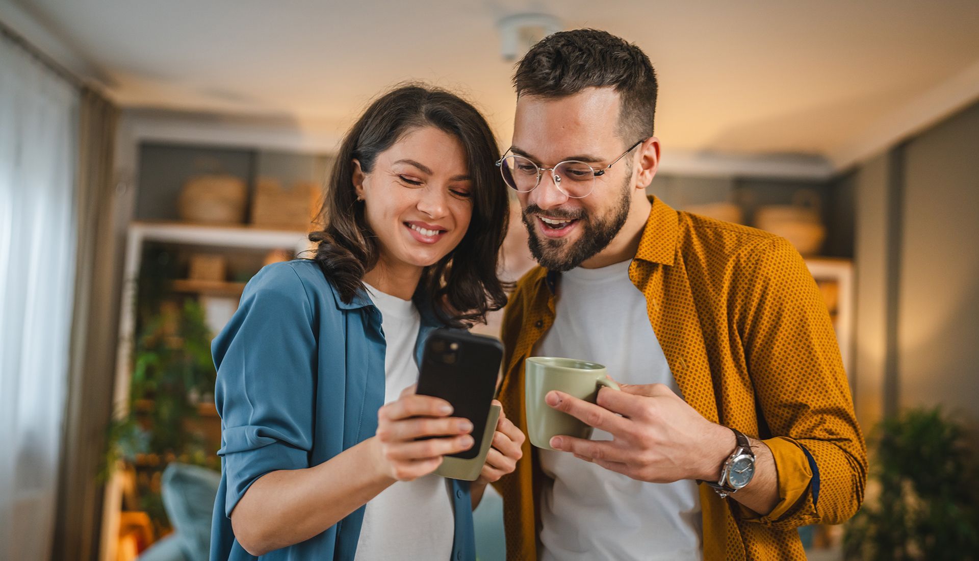 A man and a woman are looking at a cell phone together.