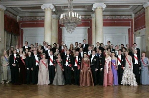 A large group of people are posing for a picture in a ballroom