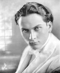 A black and white photo of a young man in a tuxedo.