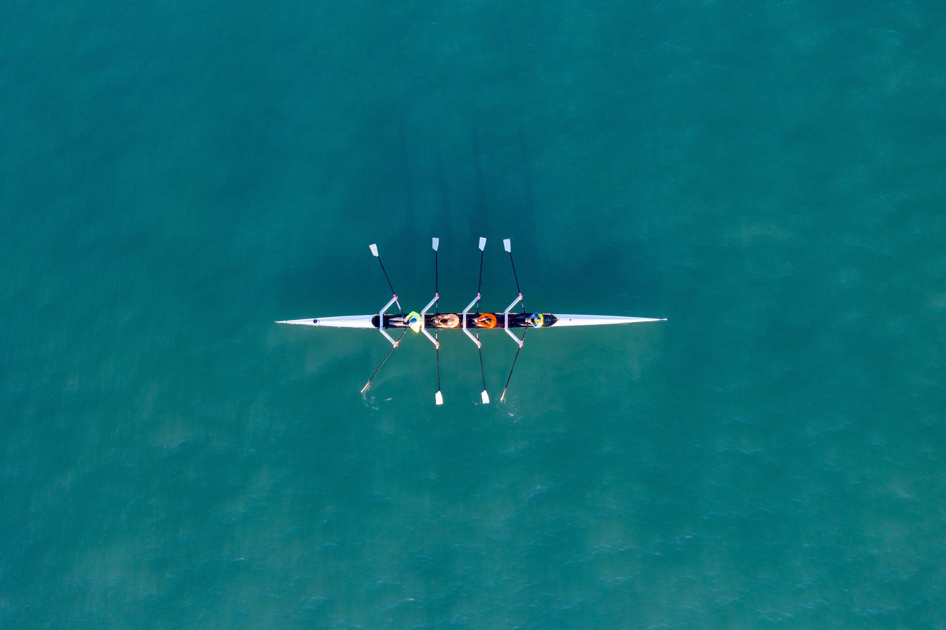 An aerial view of a rowing boat in the ocean.